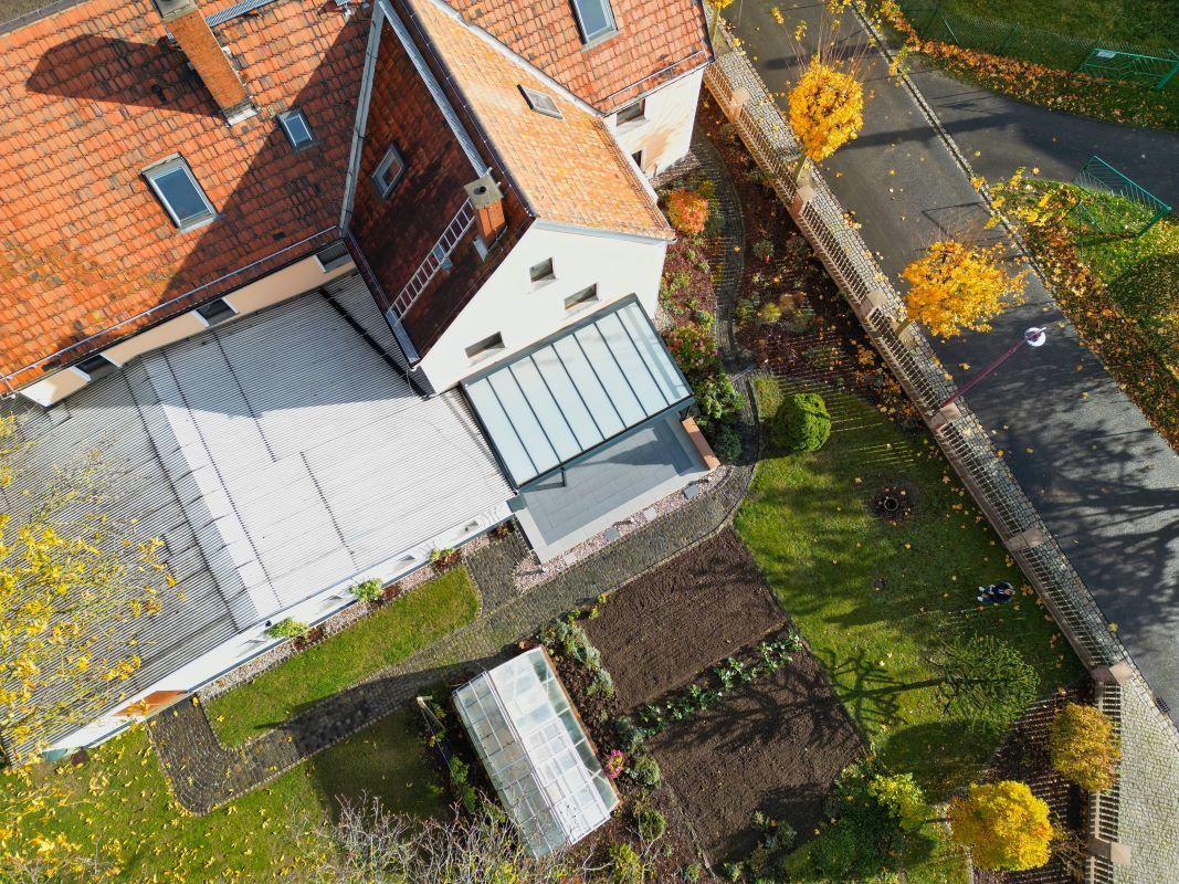 Eine Luftaufnahme eines Hauses mit einem roten Ziegeldach und einem Garten.