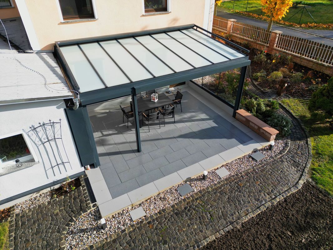 Eine Luftaufnahme einer Terrasse mit einem Tisch und Stühlen unter einem Baldachin.