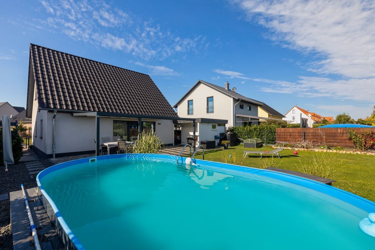 Im Hinterhof eines Hauses befindet sich ein großer Swimmingpool.