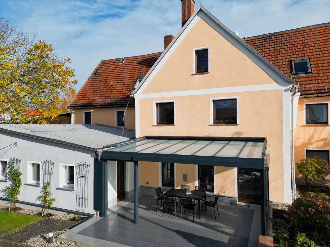 Ein großes Haus mit einer Pergola an der Seite