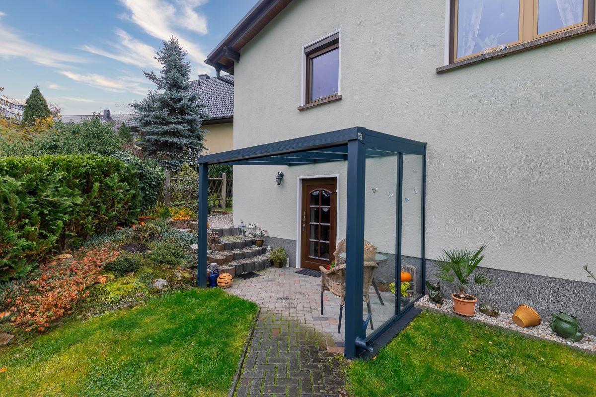 Ein weißes Haus mit einer Terrasse davor