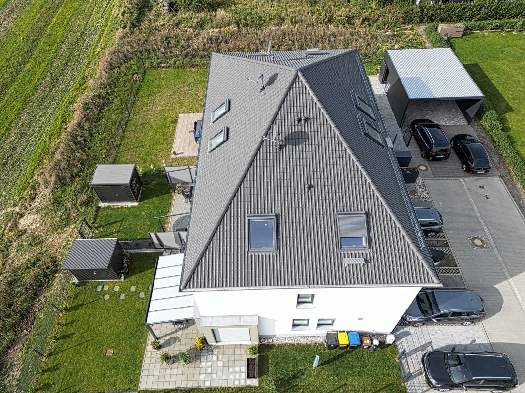 Eine Luftaufnahme eines Hauses mit davor geparkten Autos.