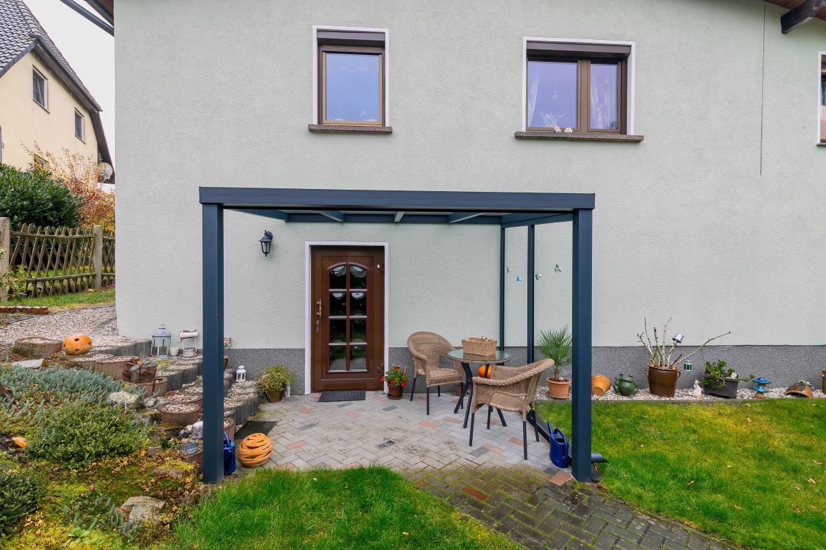 Ein weißes Haus mit einer Pergola davor