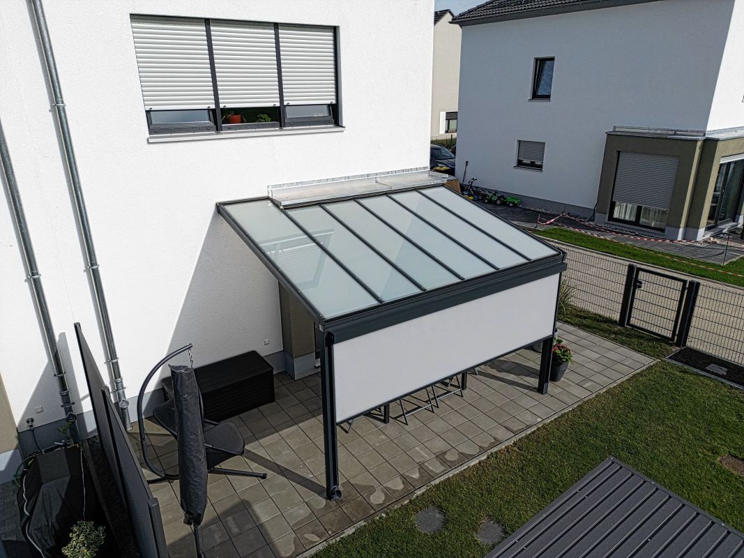 Im Hinterhof eines Hauses steht eine Pergola.