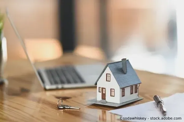 Modellhaus, Schlüssel und Laptop