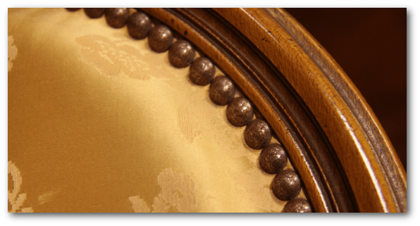 Gros plan sur le travail d'un tapissier en restauration de fauteuil