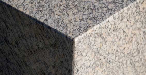 Gros plan sur un coin de granit présentant des surfaces de pierre mouchetées de clair et de foncé.