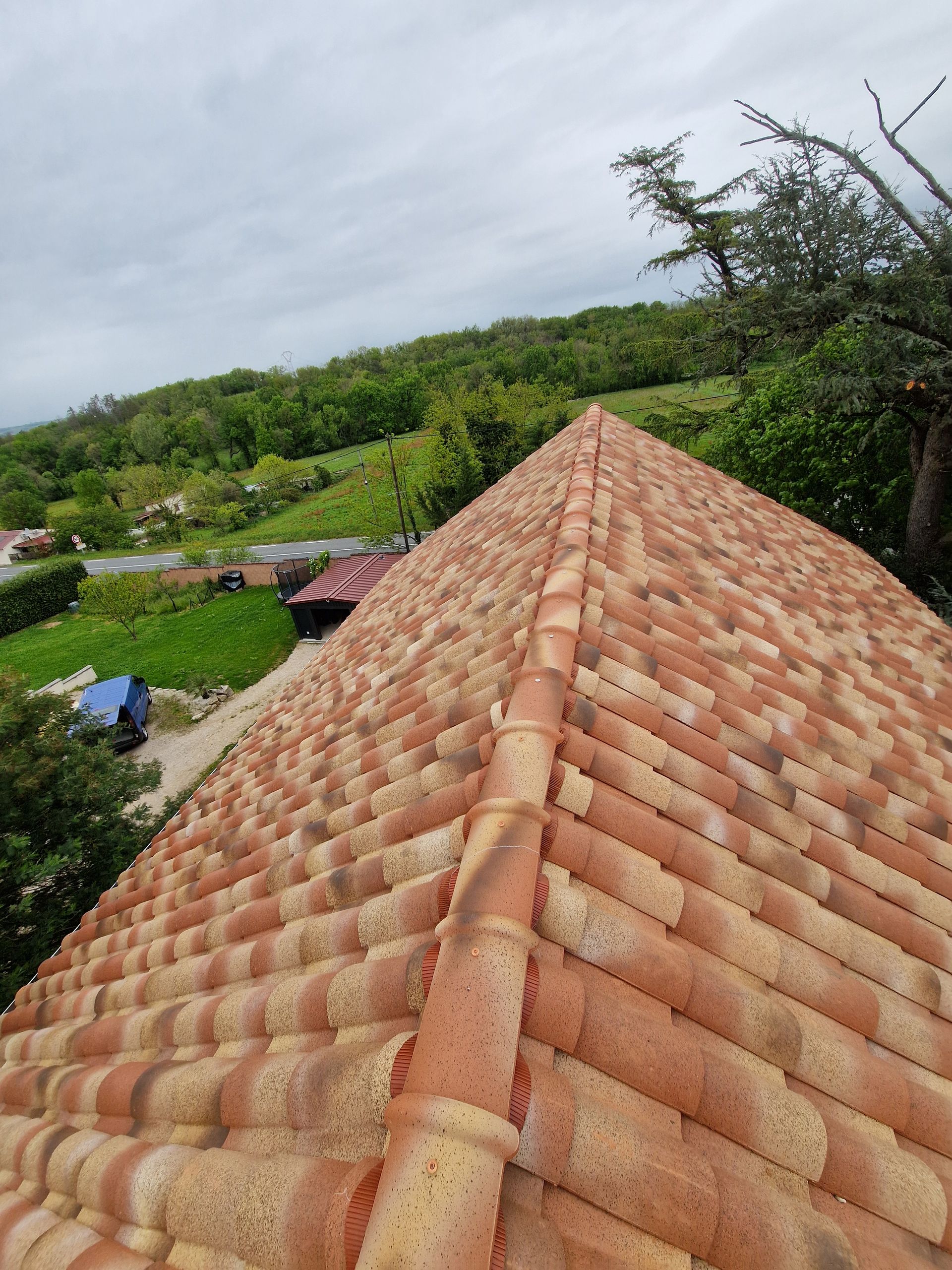 Pose de tuiles de terre cuite rouge, laissant apparaître la sous-couche et les supports en bois.