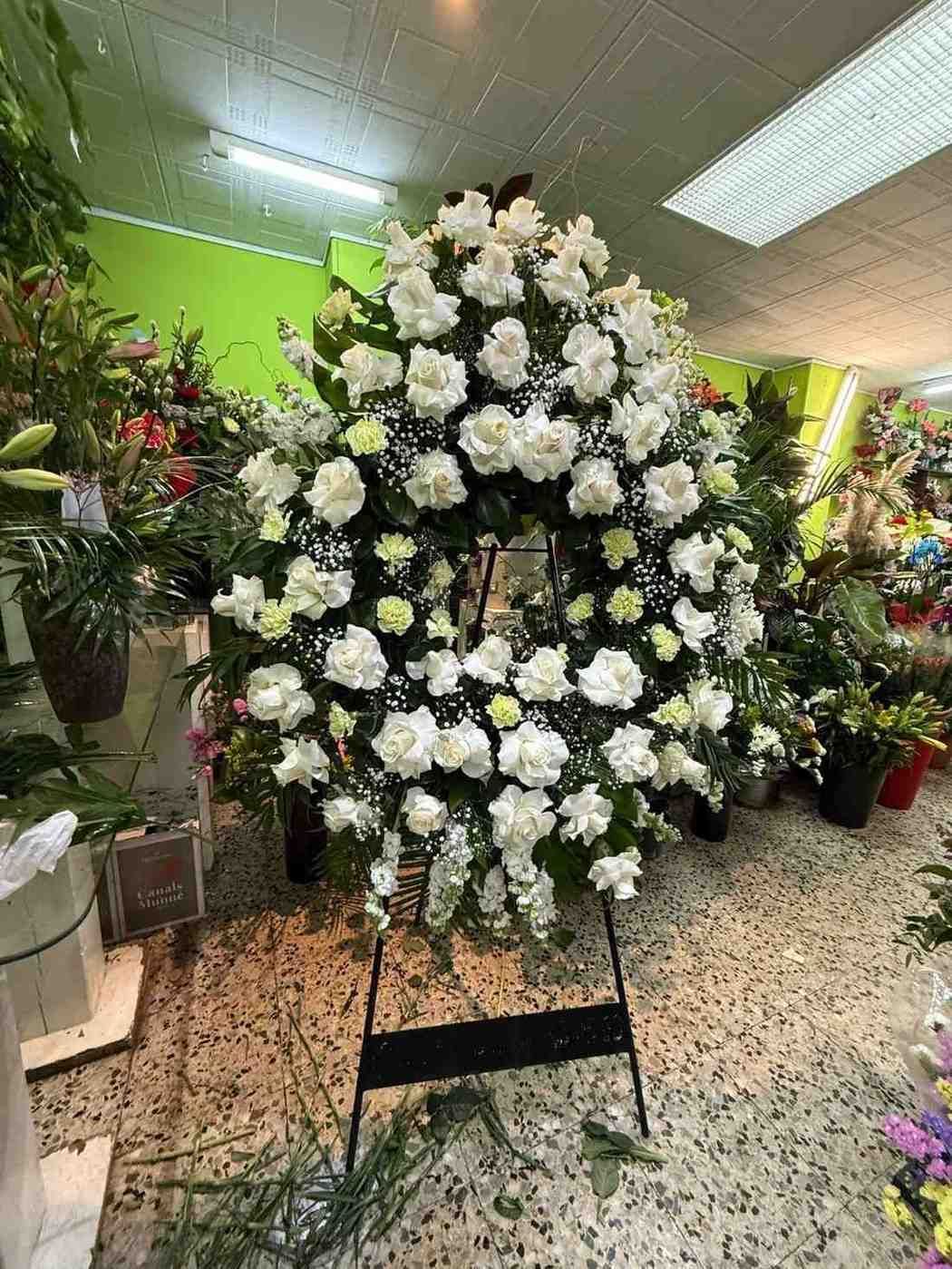 Un arreglo floral circular para funeral compuesto por crisantemos blancos