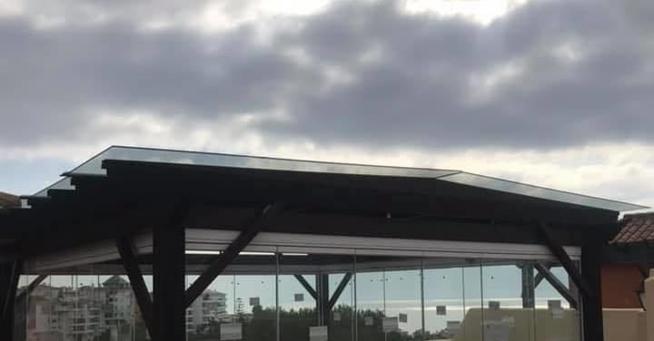 Un edificio con un techo cubierto de vidrio y un cielo nublado al fondo.