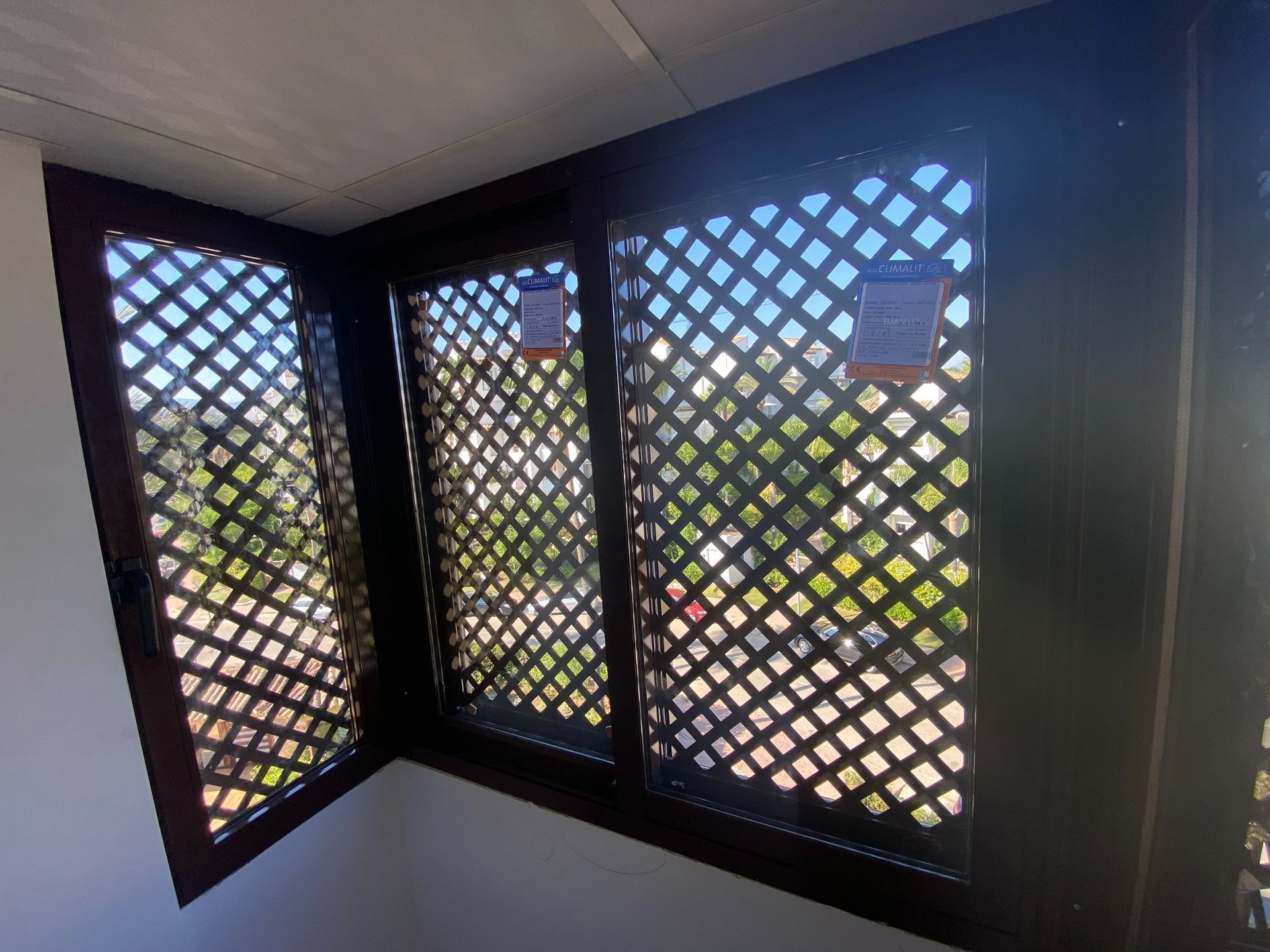 Una habitación con tres ventanas y una celosía en la pared.