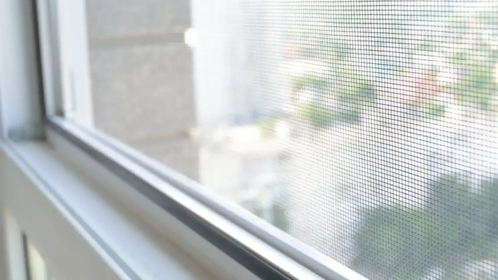 Un primer plano de una ventana con una pantalla sobre ella.