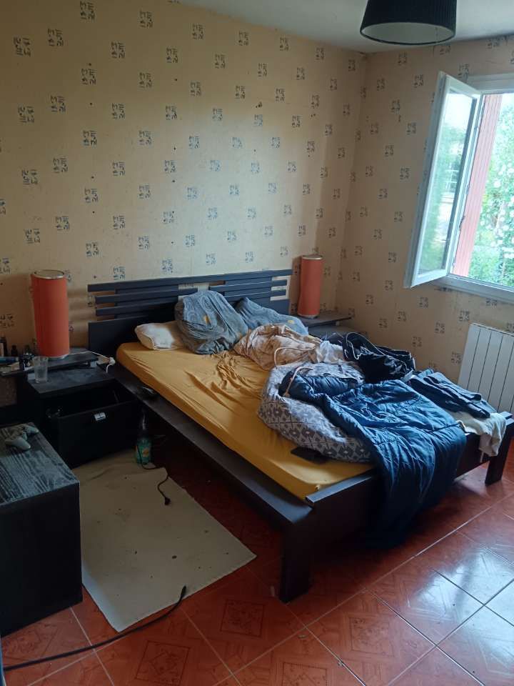 Personne en pantalon orange fluo en train de ranger étagères en fer