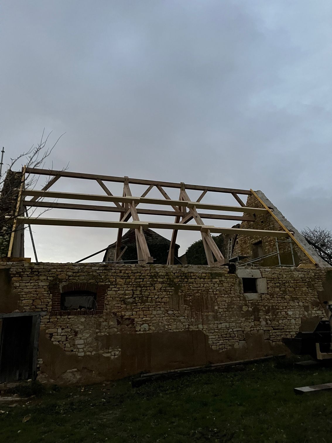 Charpente en bois en cours de conception pour la rénovation d'une maison ancienne