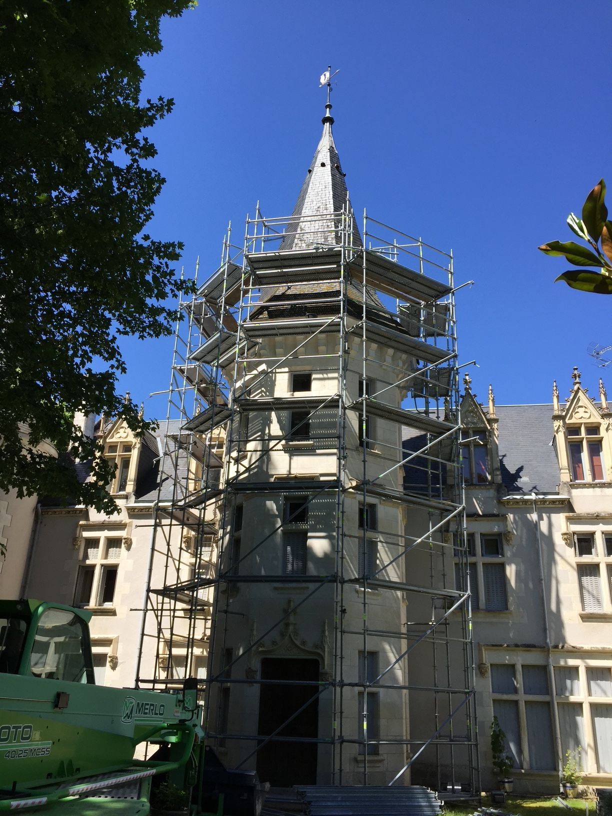 Grand échafaudage construit autour d'une tour du château Chènevière pour une intervention en toiture