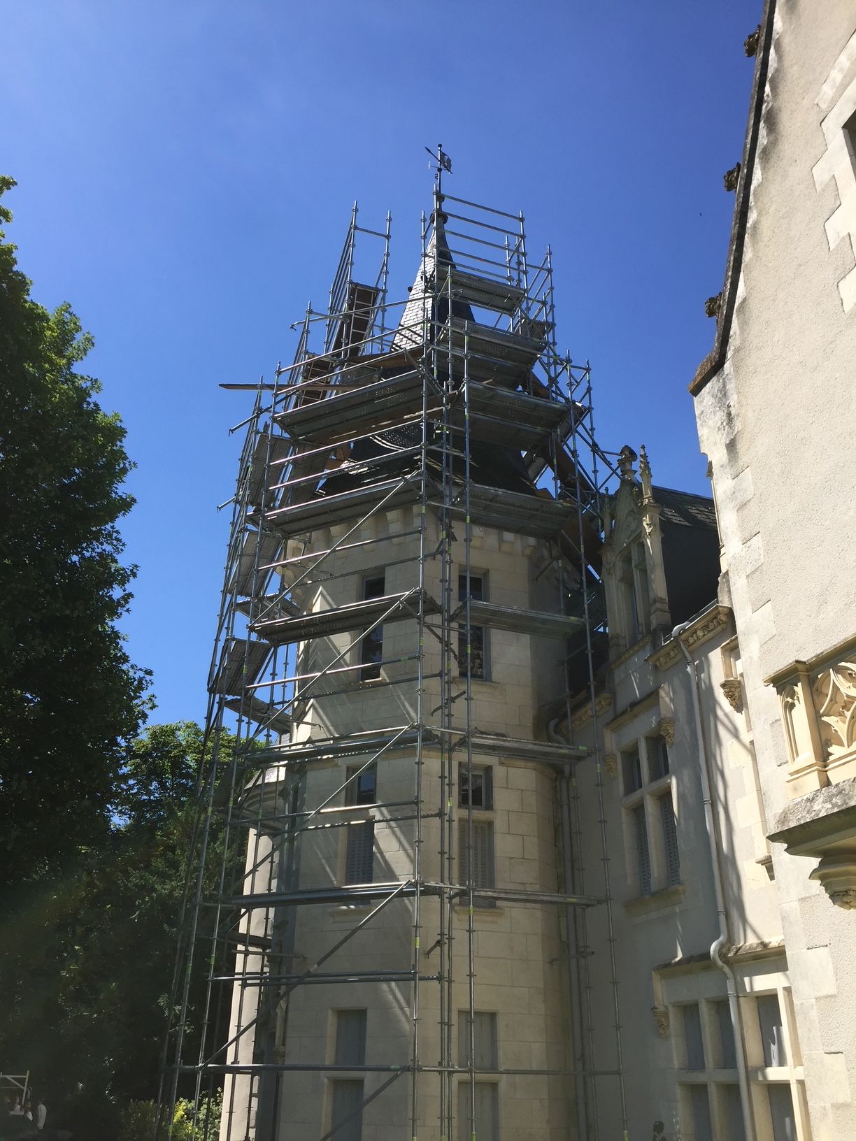 Échafaudage autour d'une tour du château Chènevière pour des travaux en couverture de toit