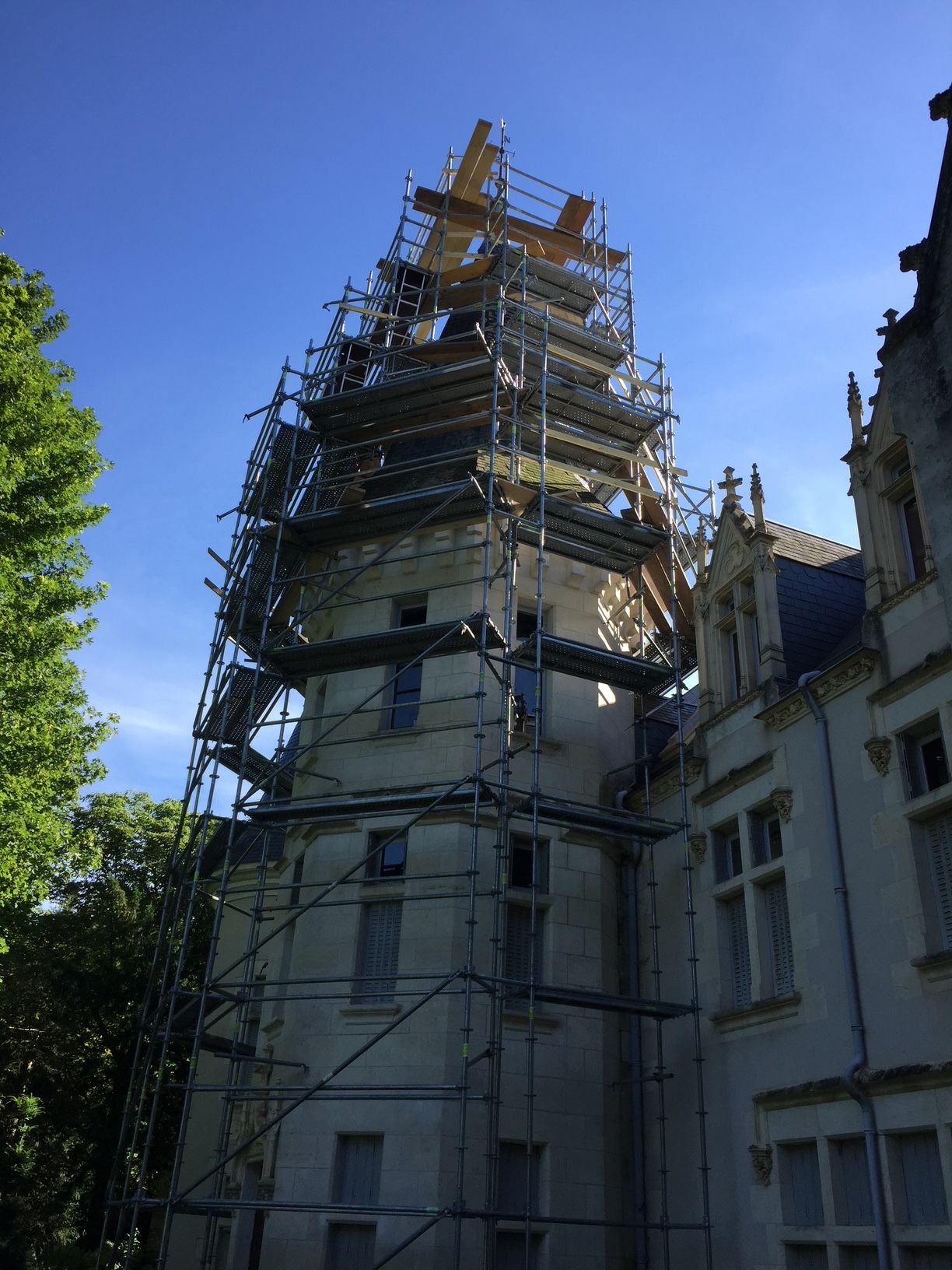 Échafaudage autour d'une tour du château Chènevière pour des travaux de toiture