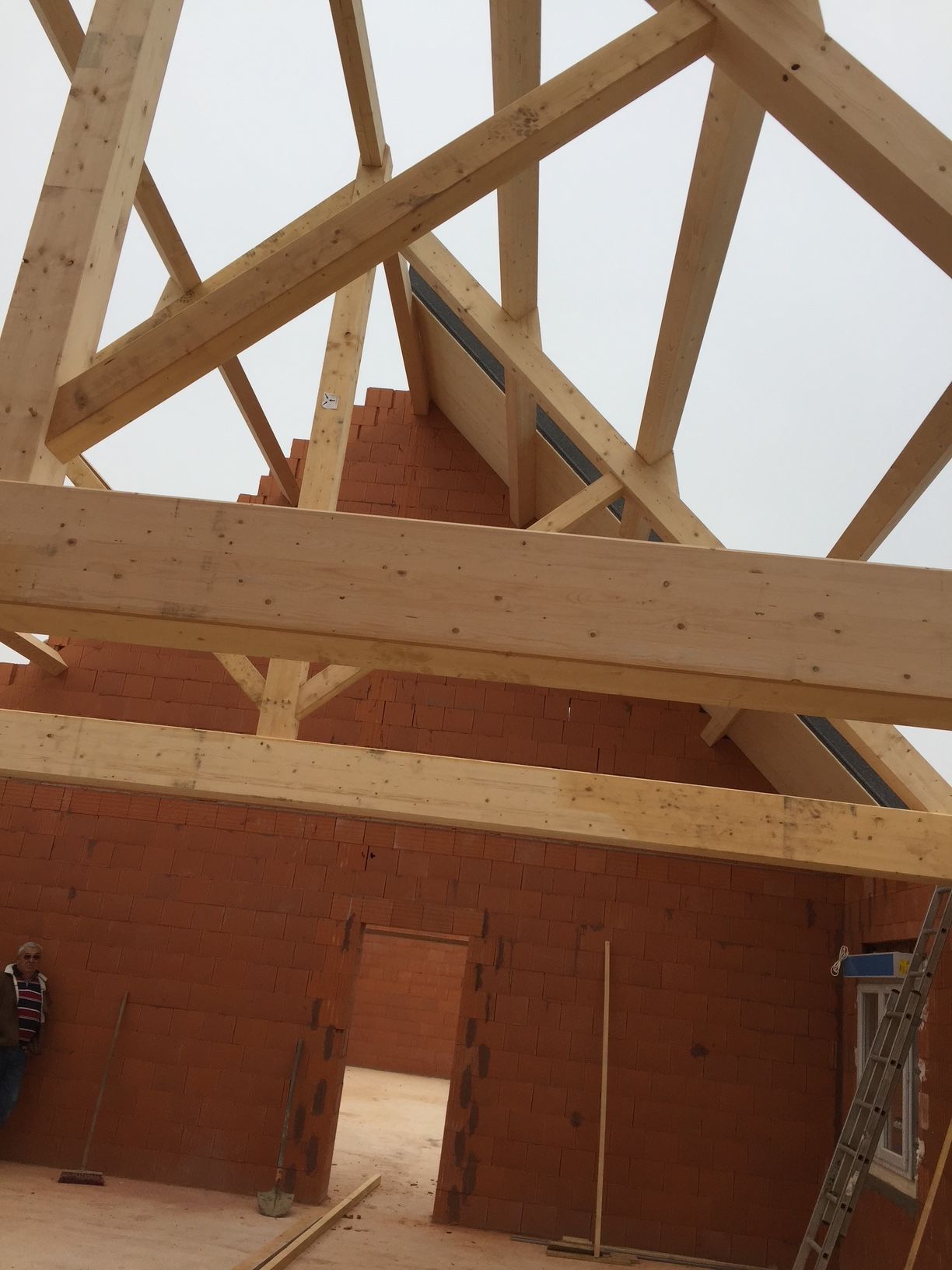 Maison en construction avec mur en pierre et charpente en bois