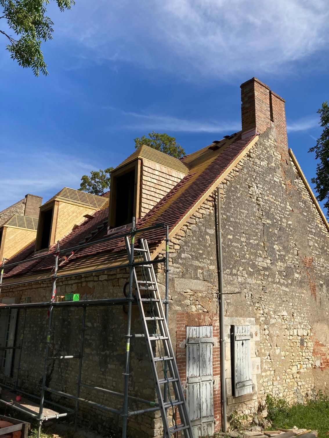 Vue d'ensemble d'une maison traditionnelle avec une toiture rénovée