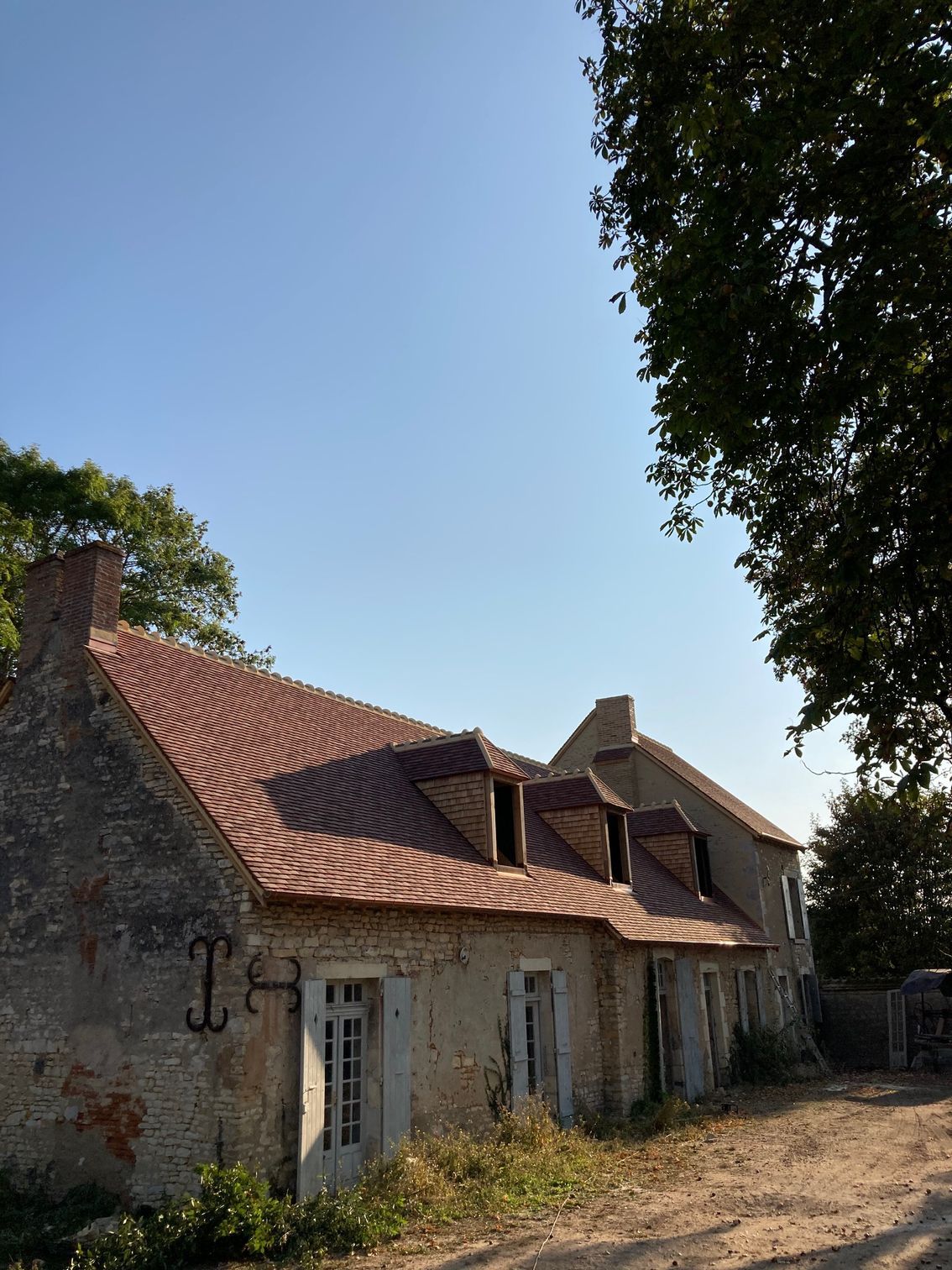 Toiture de maison individuelle rénovée avec des ardoises marron