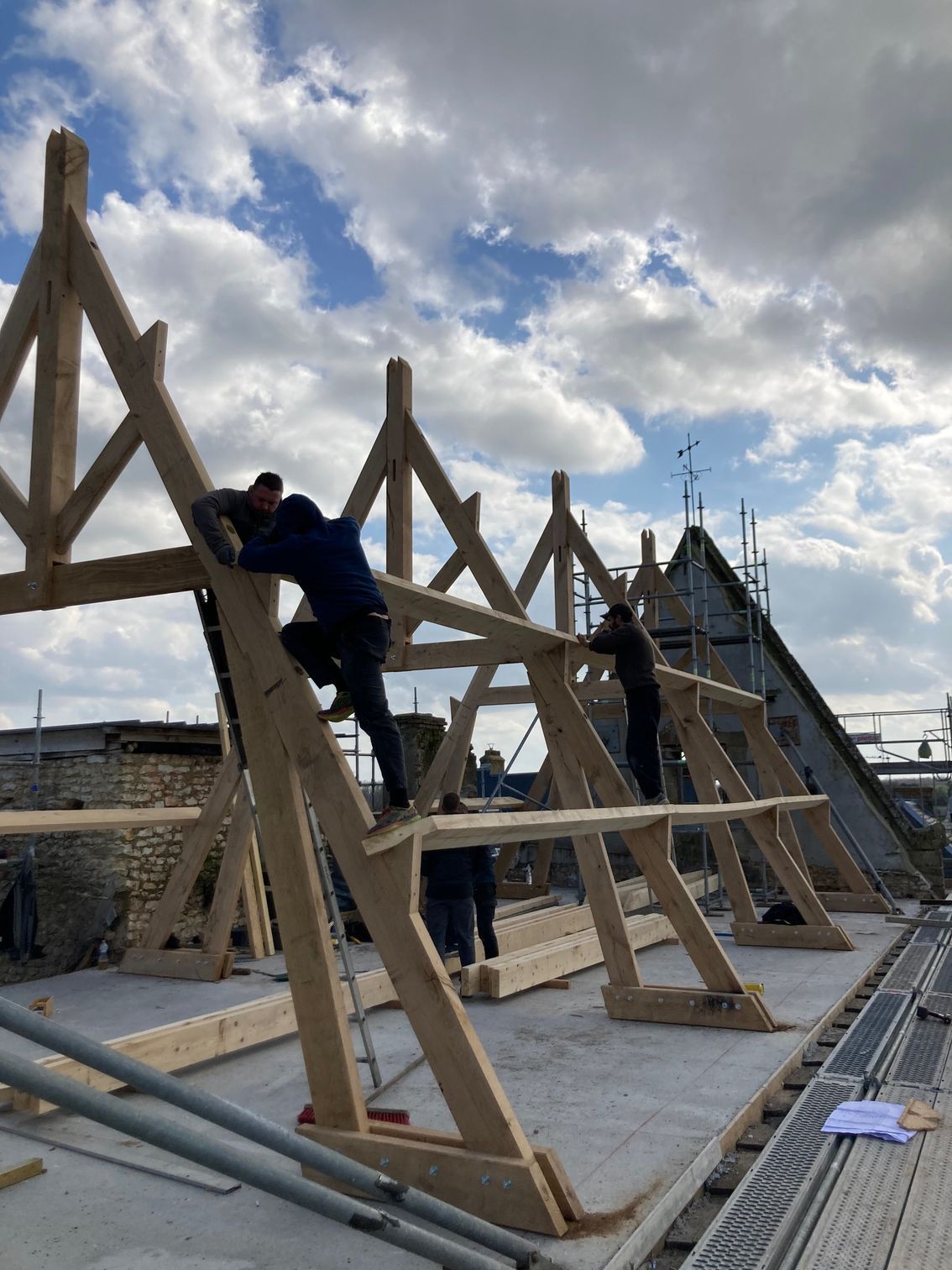 Charpentiers en cours d'élaboration d'une charpente traditionnelle en toiture