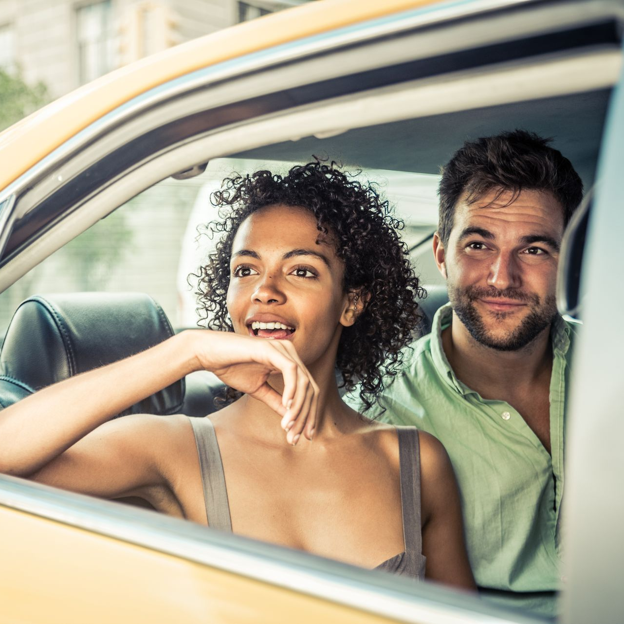 Un couple souriant à l’intérieur d’une voiture