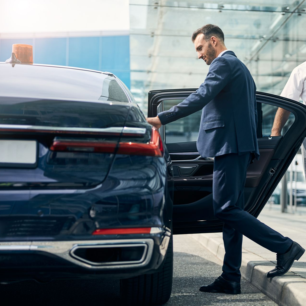 Un chauffeur ouvrant la porte d’un véhicule pour un passager