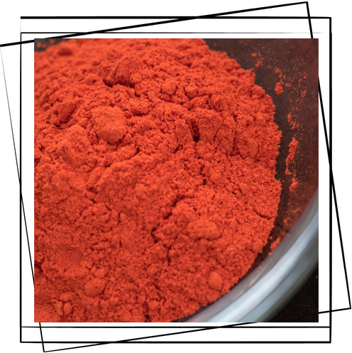 Un primer plano de polvo rojo en un recipiente.