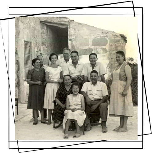 Un grupo de personas posa para una fotografía frente a un edificio de piedra.