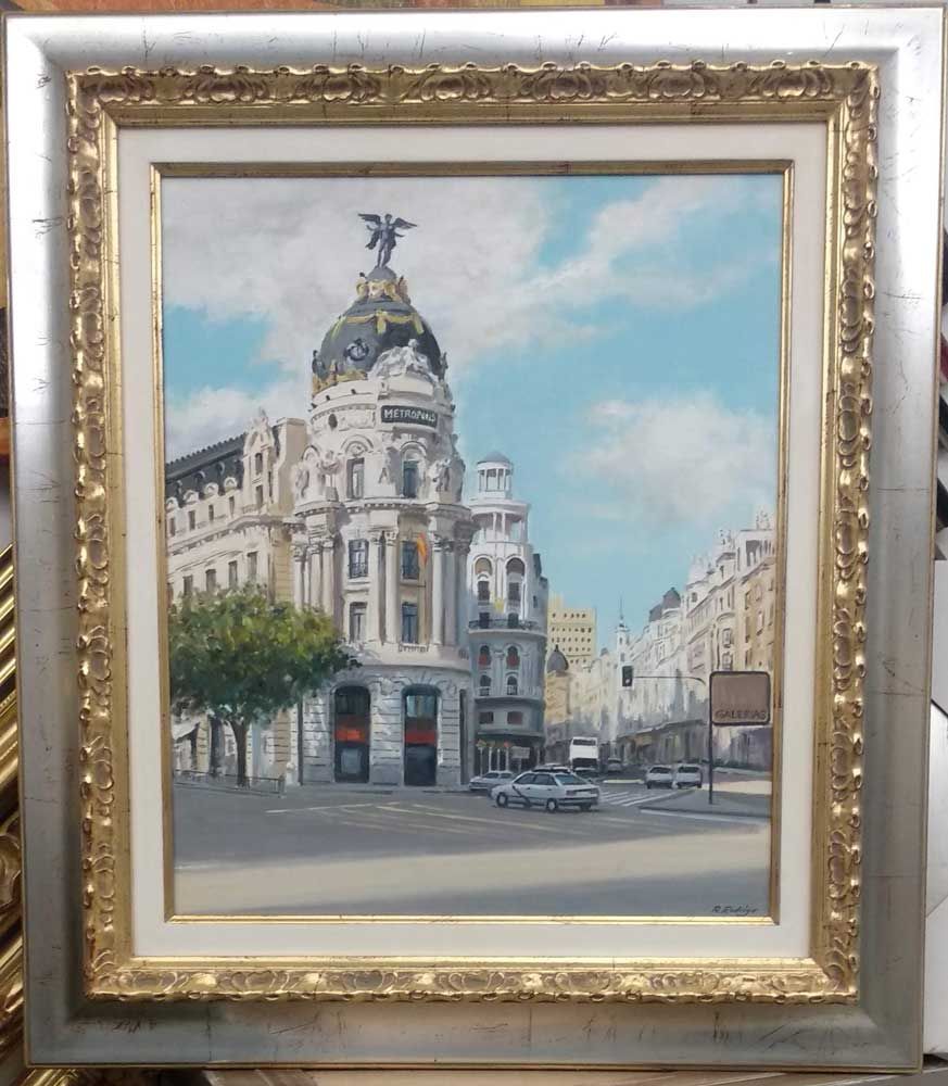 Pintura del edificio Metrópolis en Madrid, España, con cielo y calle azules.
