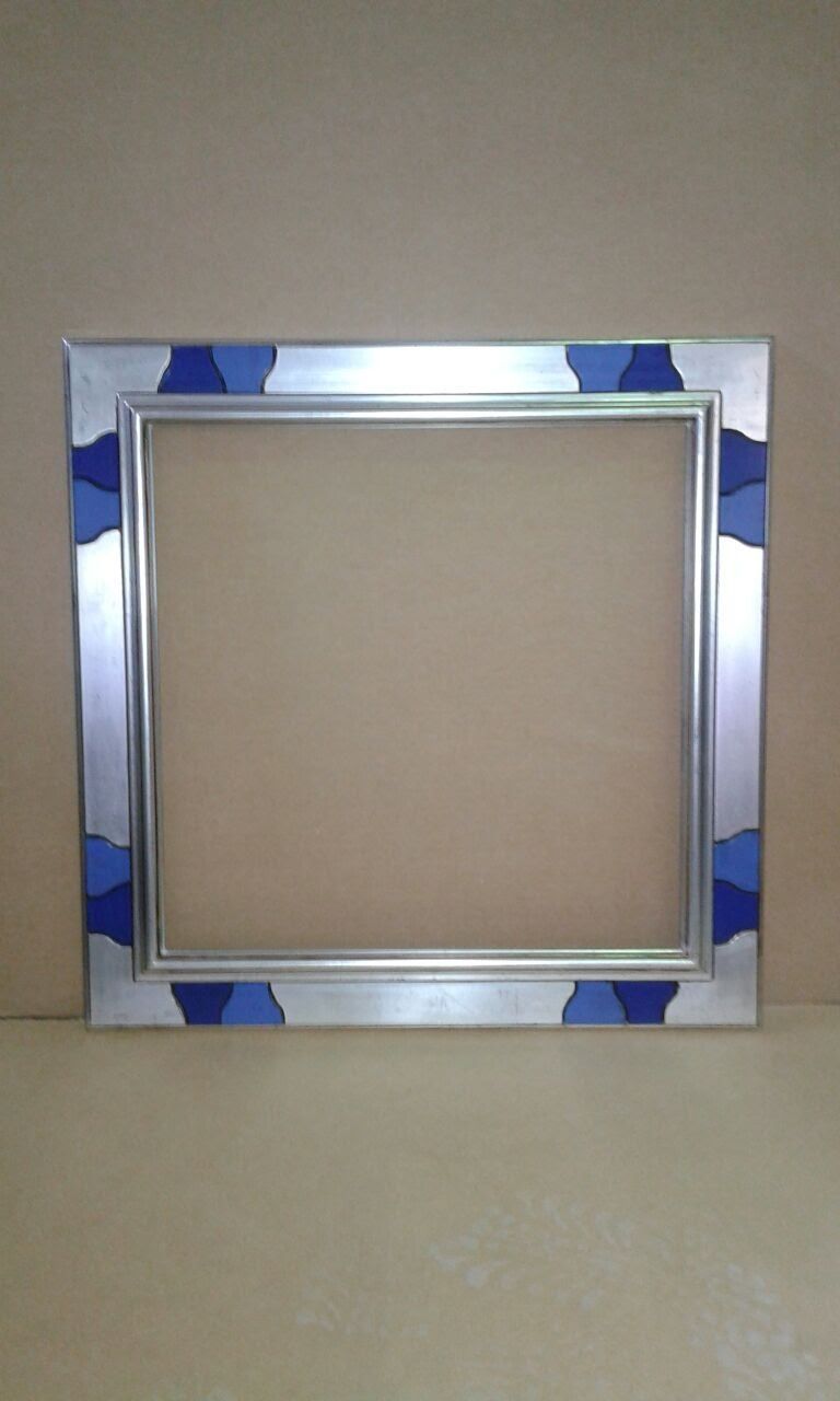 Marco cuadrado plateado con acentos geométricos azules, centro vacío.