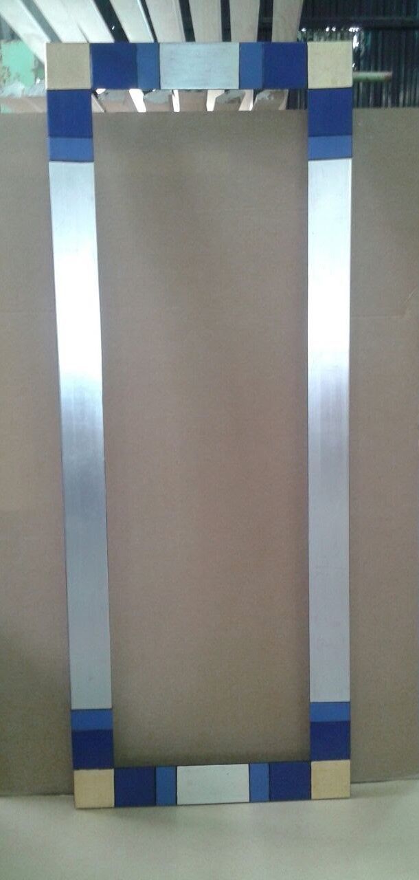 Un marco rectangular plateado y azul con cuadrados azules decorativos sobre un fondo marrón claro.