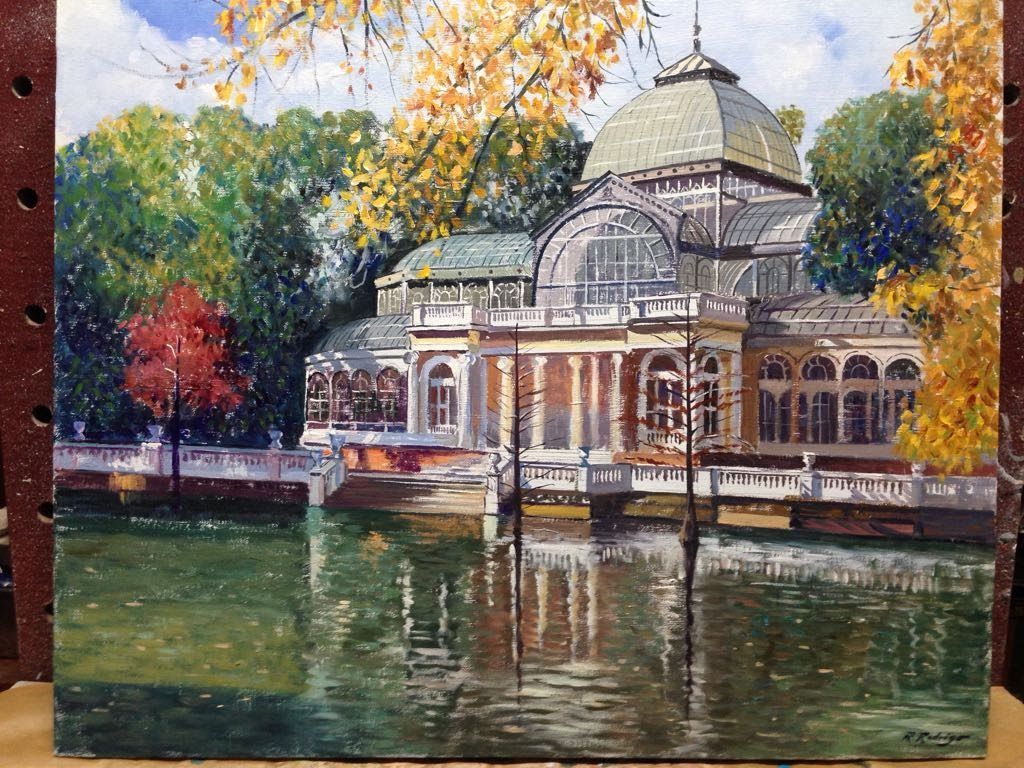 Pintura de un edificio de vidrio y hierro reflejado en un estanque, hojas de otoño al fondo.