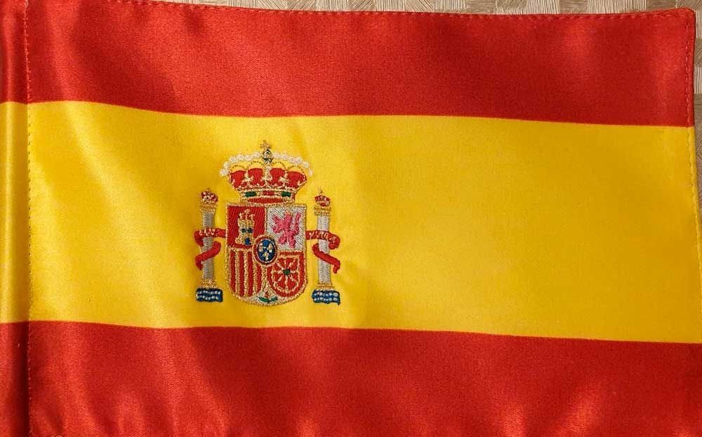 Bandera de España con franjas rojas y amarillas, escudo en la franja amarilla.