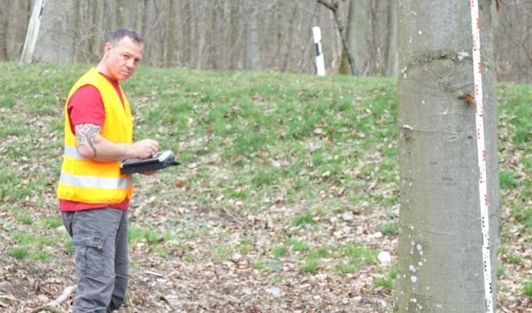 Mann mit Sicherheitsweste bei der Vermessung