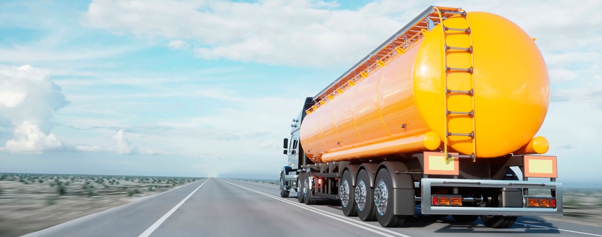 Un camión cisterna amarillo circula por una autopista.