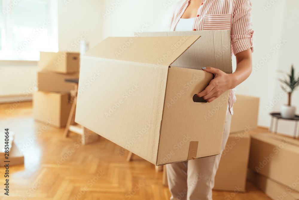 Mitarbeiter der Rebo Transport GmbH trägt Umzugskarton