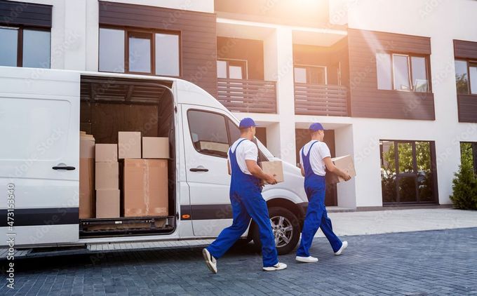 Mitarbeiter der Rebo Transport GmbH mit Van voller Umzugskartons