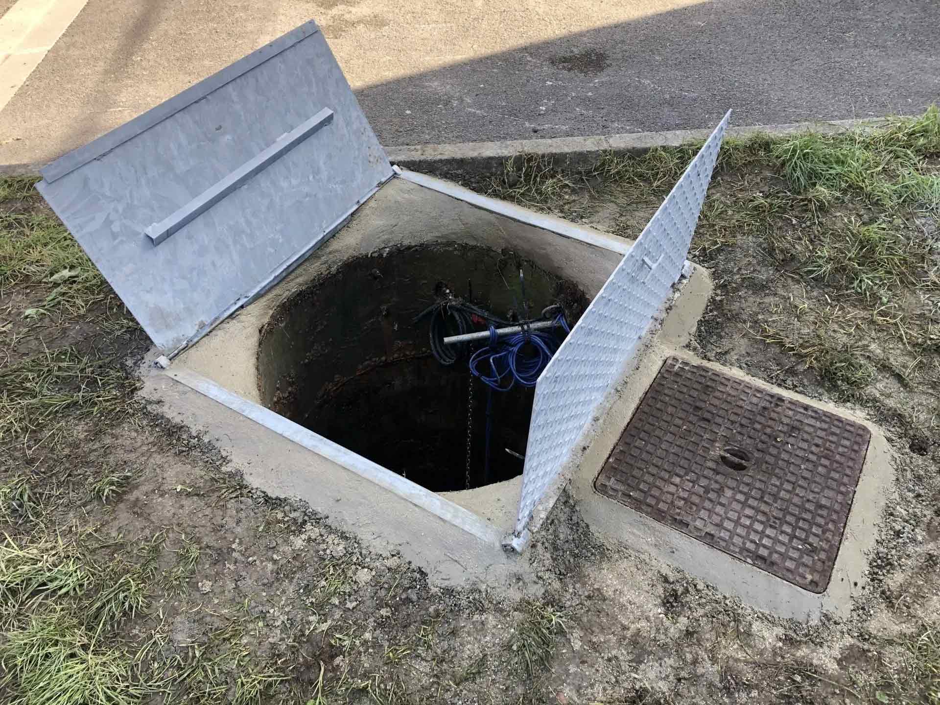 Bouche d'égout ouverte pour travaux d'assainissement par l'entreprise Féchain Vidanges