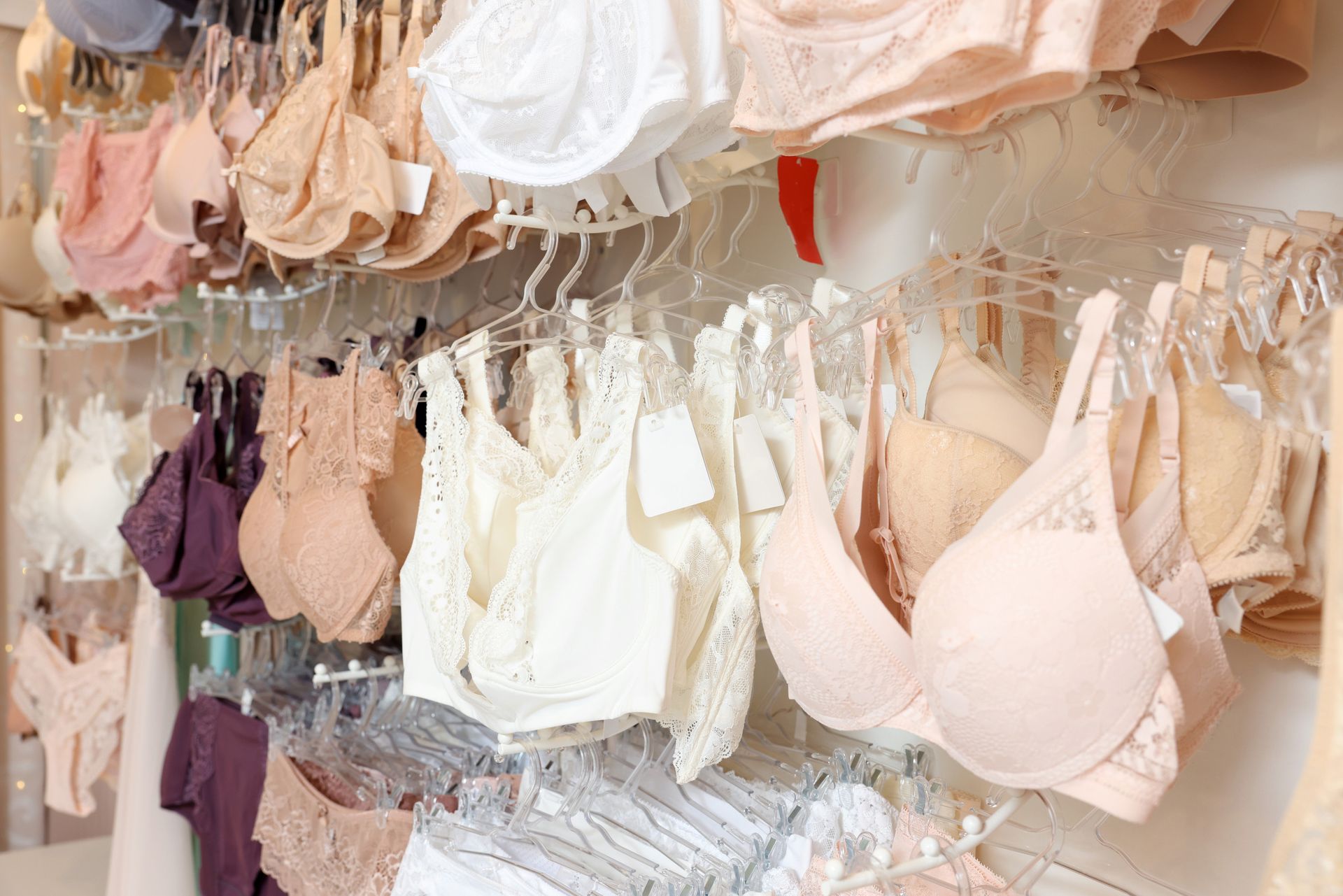 Una variedad de sujetadores están colgados en un estante en una tienda.