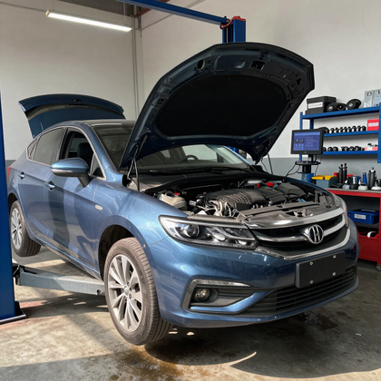Sedán Honda azul con el capó abierto en un garaje, probablemente en mantenimiento o inspección.