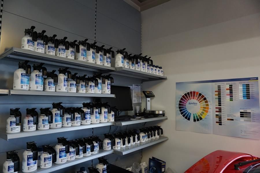 Ein Haufen Farbflaschen stehen auf Regalen in einem Raum