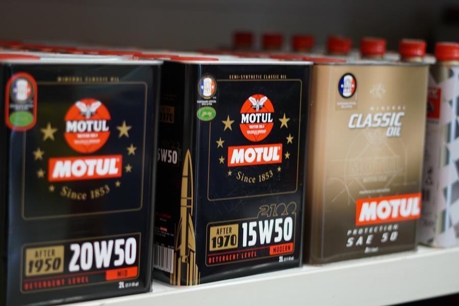 Auf einem Regal stehen drei Kisten Motul-Öl.