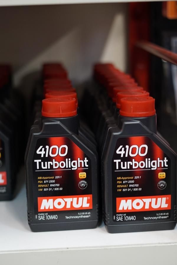 Zwei Flaschen Motul 4100 Turbolight stehen auf einem Regal