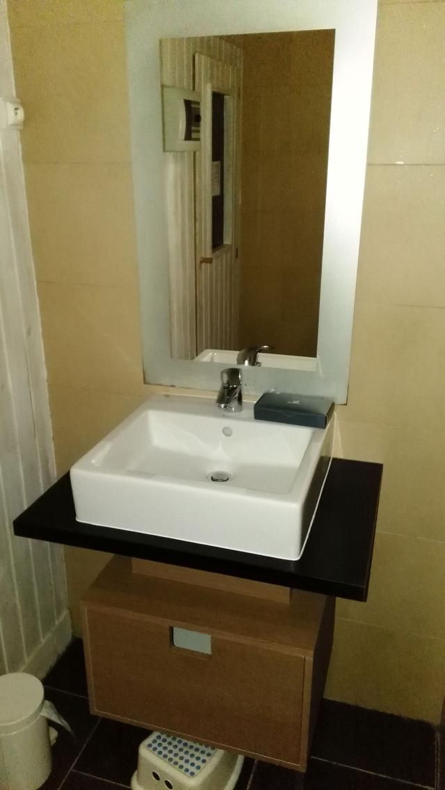 Lavabo de salle de bains avec miroir, fixé au-dessus d'un meuble-lavabo et d'une étagère