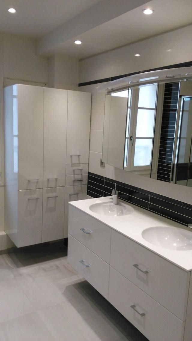 Salle de bains moderne blanche avec meuble-lavabo à double vasque, armoires de rangement hautes et grand miroir