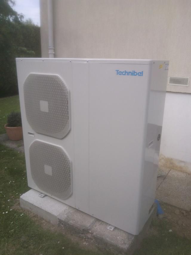 Unité de pompe à chaleur Technibel blanche, extérieure, avec deux grilles, à côté d'un bâtiment