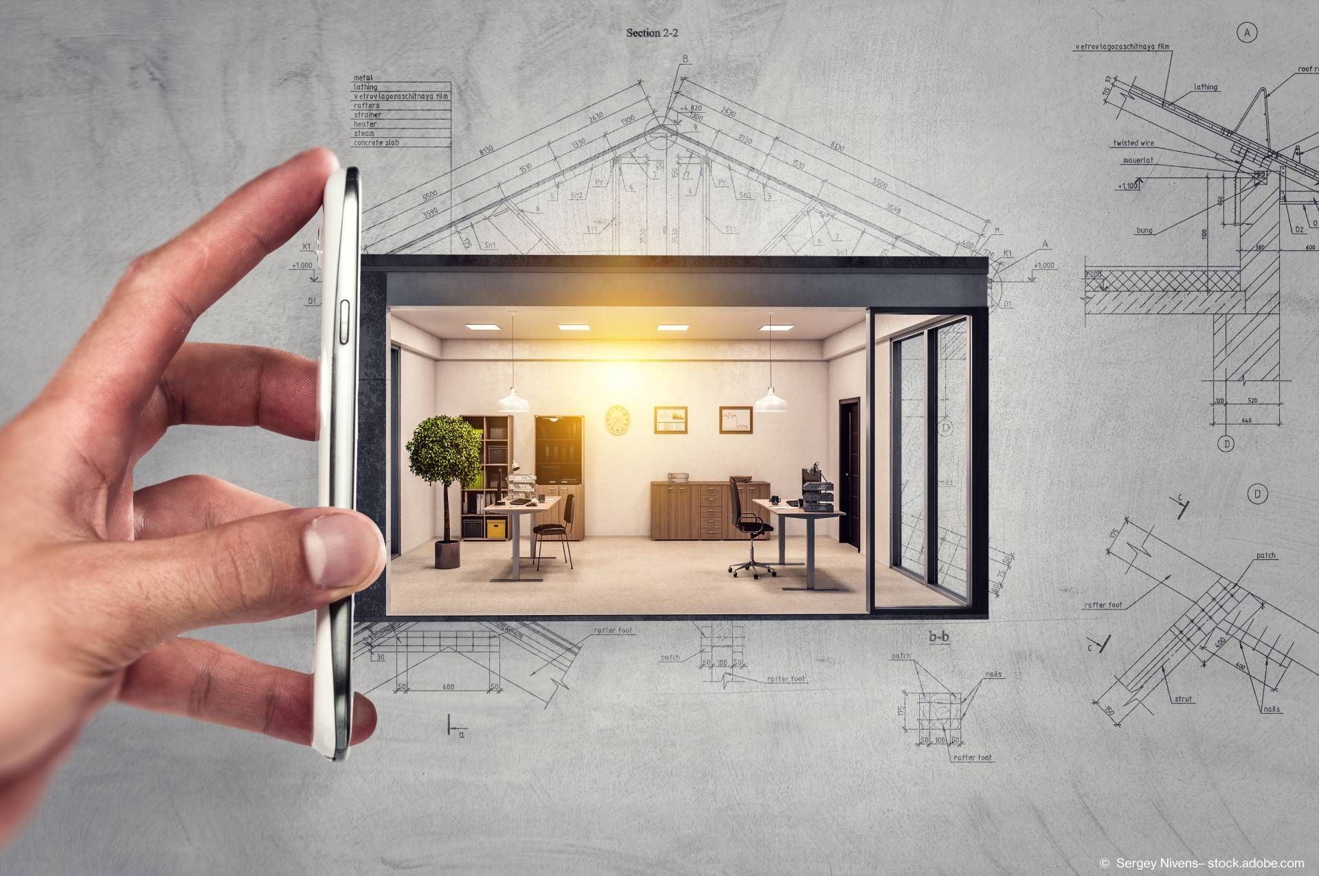 Eine Hand hält ein Handy an ein kleines Modell von einem Raum