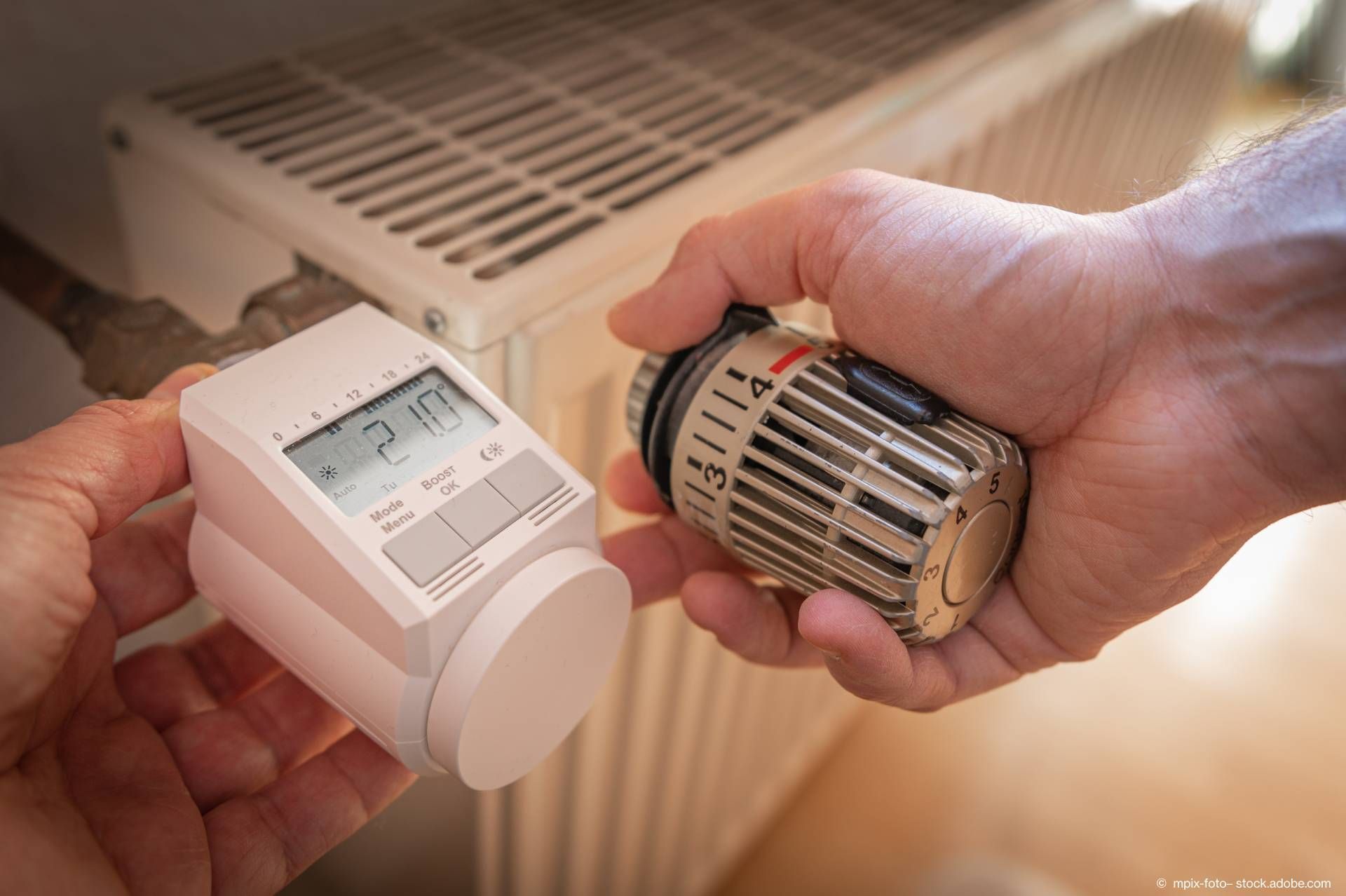Eine Person dreht eine Heizung auf