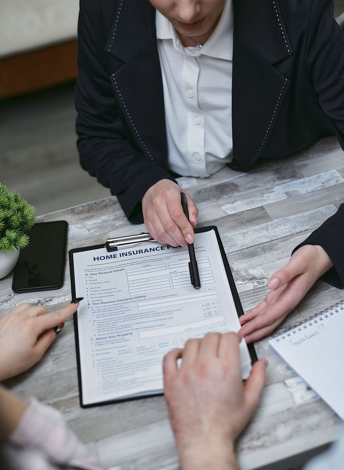 Personas revisando una lista de verificación sobre una mesa, con un portapapeles y un bolígrafo, en una oficina